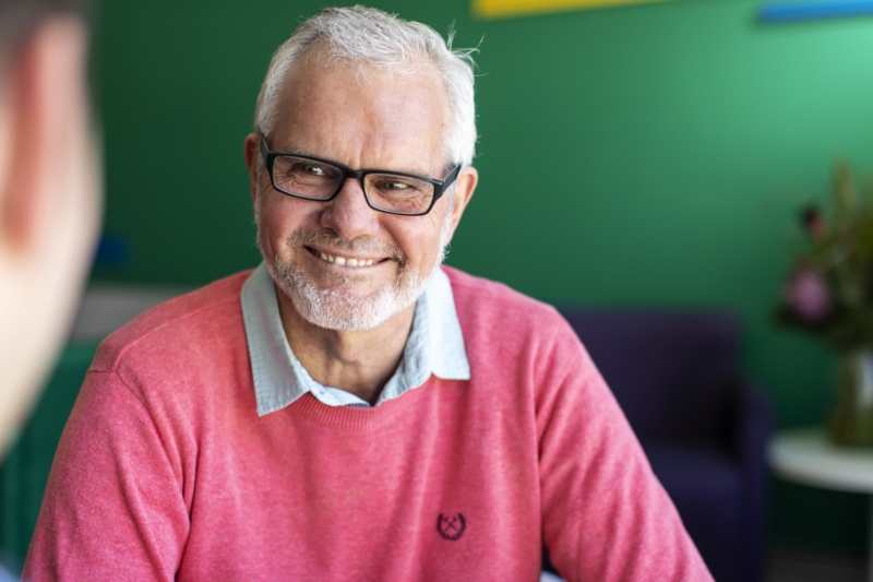 Older cancer patient smiling at Icon care team member